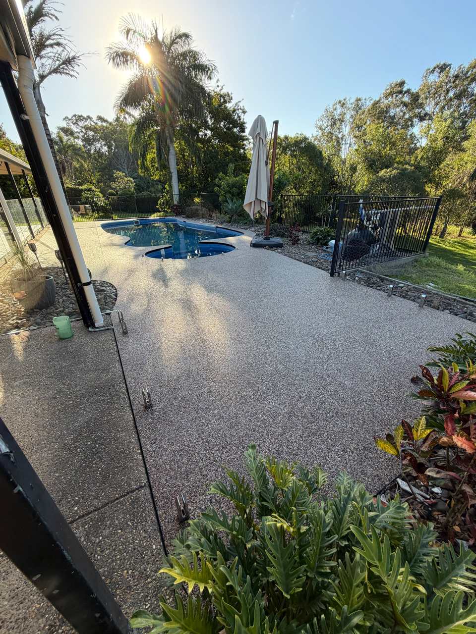 Tan blend pool deck with palms